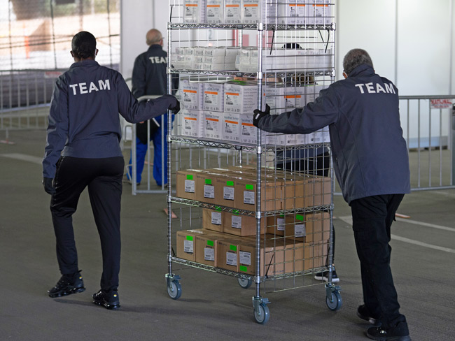 health care employees moving a cart of medical supplies