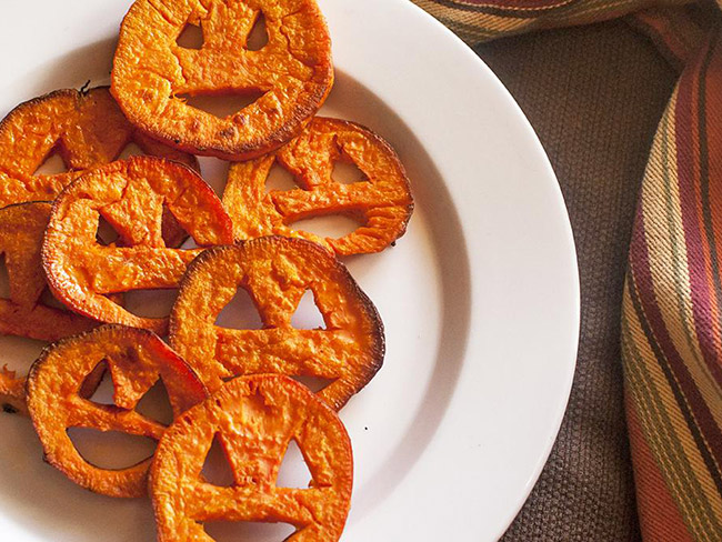 Sweet potato jack-o'-lanterns on a white plate.