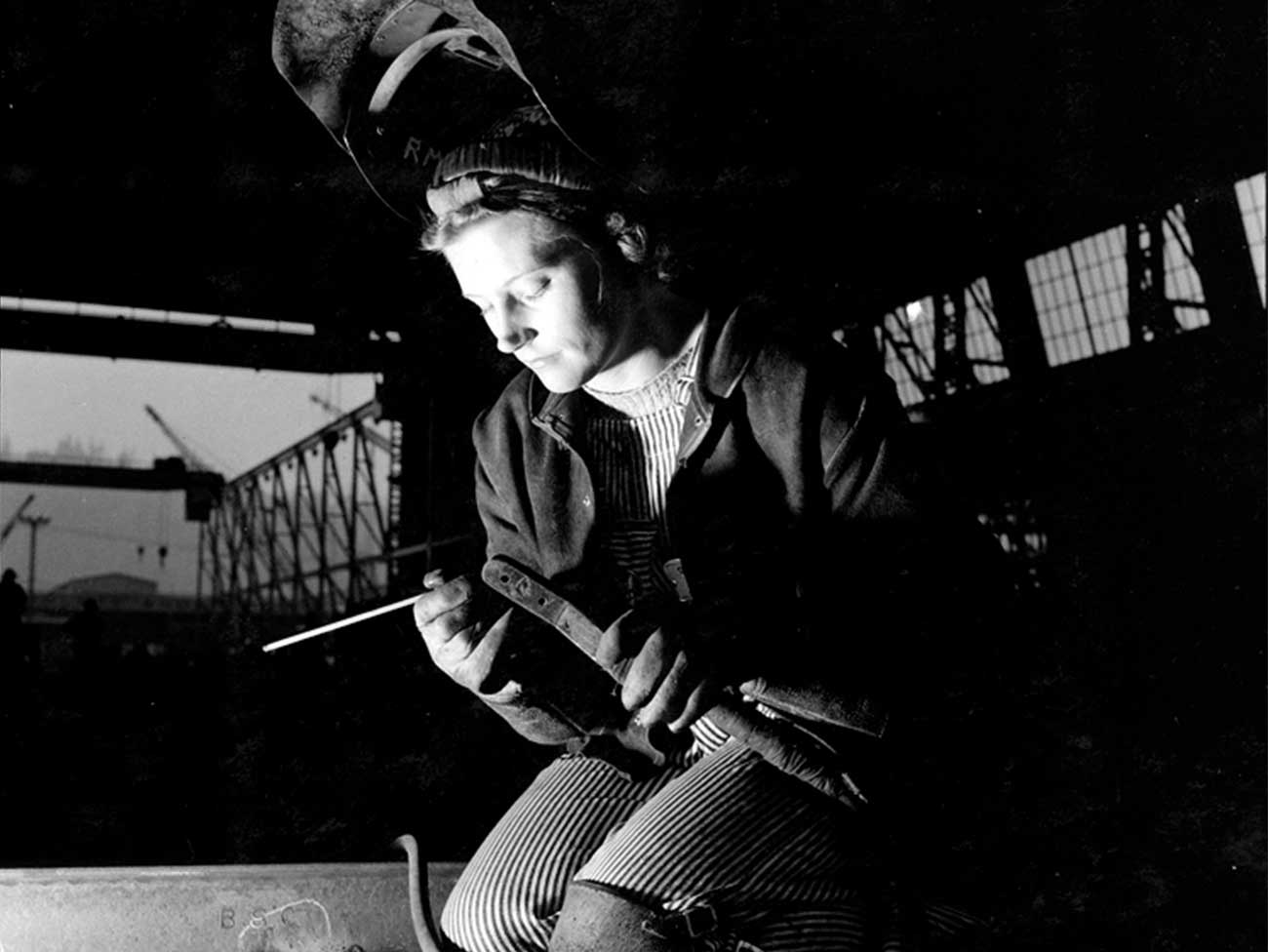 Historical image of a female welder at work during World War II. 