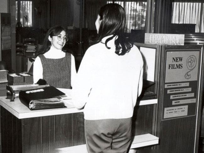 Health Education Library, librarian Caren Quay at desk, circa 1974.
