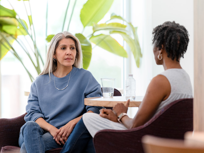 2 woman seated and talking during therapy session