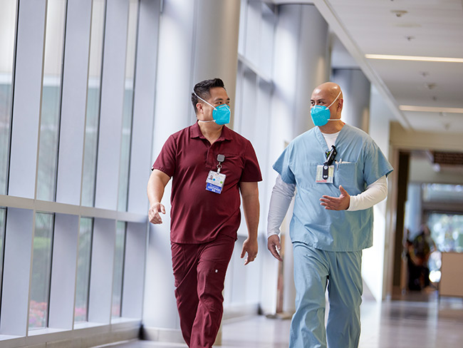 2 male nurses walking down corridor