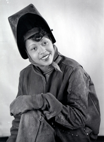 Gladys Theus posing in a welding outfit