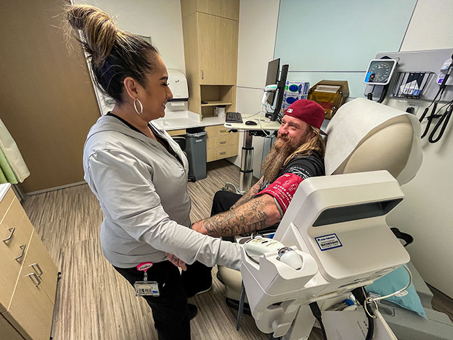 Patricia Ortiz treats Michael Schmidt in medical office