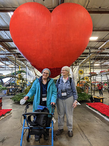 Lynn and her sister Gail standing in front of a giant red heart