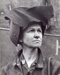 Mary Carroll in welding gear with the 1942 Merit pin on her collar.