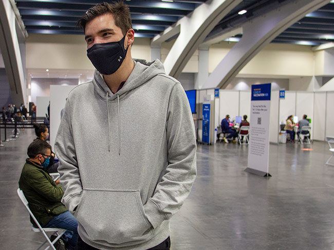 Man standing in waiting area with mask on. 