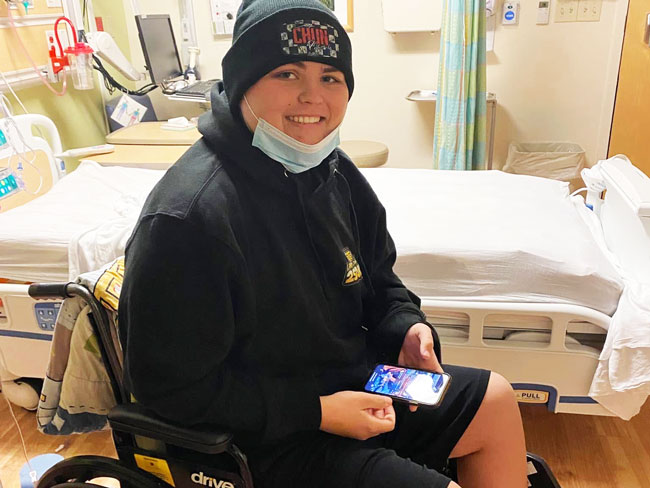 smiling young man in wheelchair near hospital bed