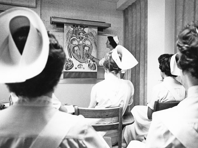 Women in nursing attire in the classroom at Kaiser Foundation School of Nursing, circa 1960.