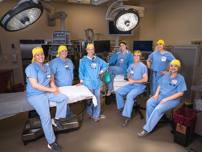 healthcare workers in blue scrubs and yellow pas