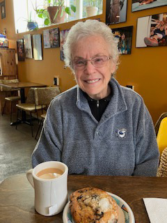 Roberta enjoys coffee and a pastry at a restaurant