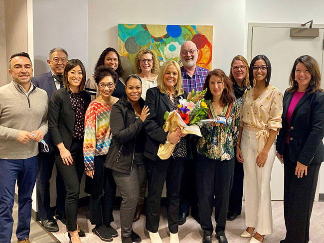 Valerie Dionne (center holding flowers) poses with some of her colleagues at the Kaiser Permanente Behavioral Health Training Institute.
