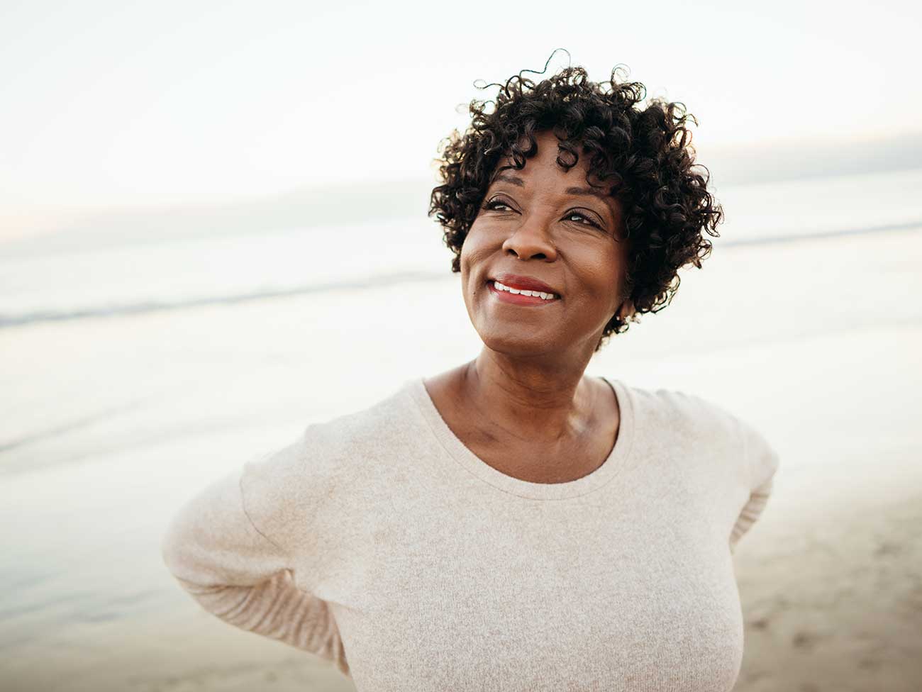 Hopeful looking African American woman on the beach.