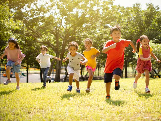 group of children running in a park