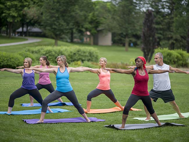 Group of people doing yoga in the park.