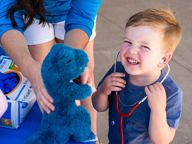 child plays with a stethoscope
