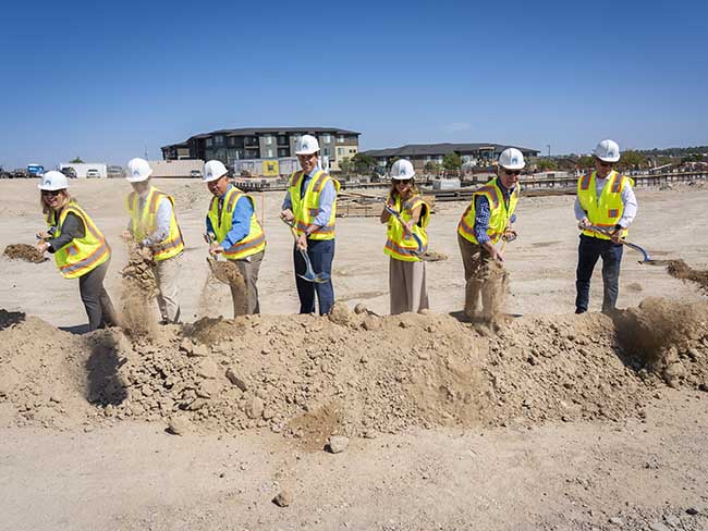 A group wearing hard hats breaks ground at the new Pueblo facility event.