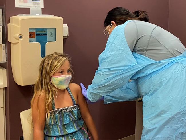 Alexis Ceniceros, a registered nurse, gives 8-year-old Kiera Meeker an injection as part of the COVID-19 vaccine clinical trial for kids underway at Kaiser Permanente Sacramento Medical Center.