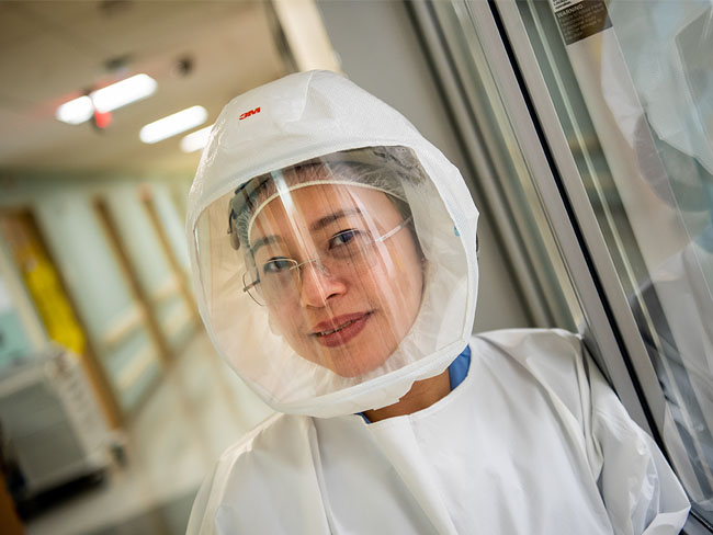 female medical worker wearing full protective gear and face shield