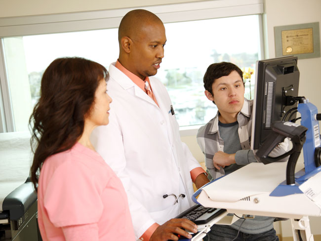 doctor and assistant reviewing a computer monitor with patient