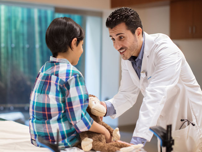 doctor in exam room with young boy patient
