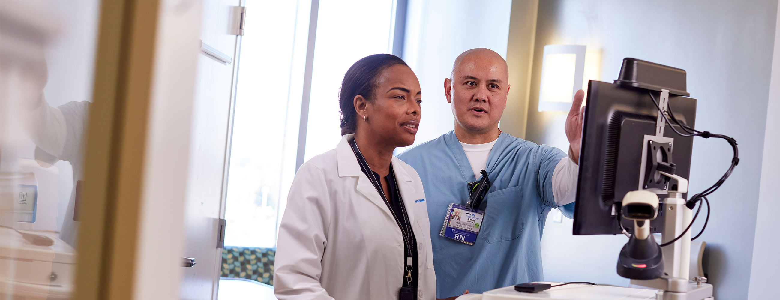 Doctor and nurse in discussion while looking at a monitor.