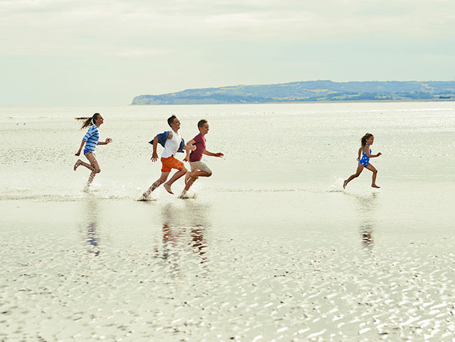 A family running on the beach