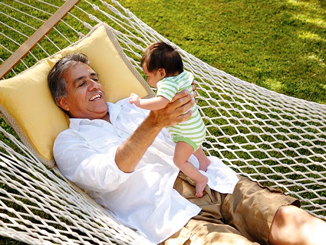 Grandpa holding baby in a hammock