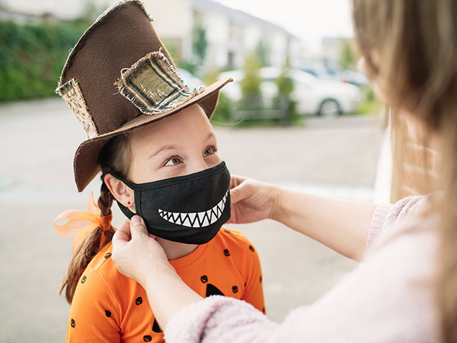child wearing face mask with printed graphic of sharp teeth