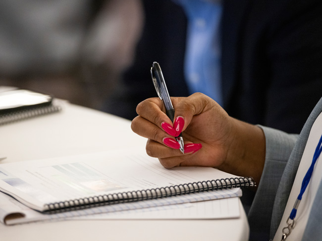 hand holding a pen writing on a notebook