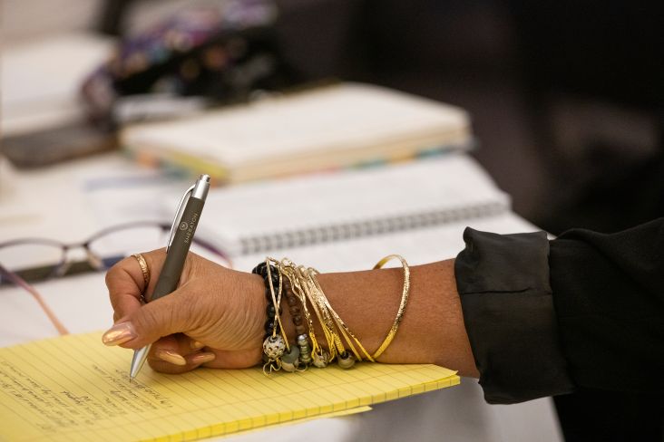 Hand with bracelets holding pen