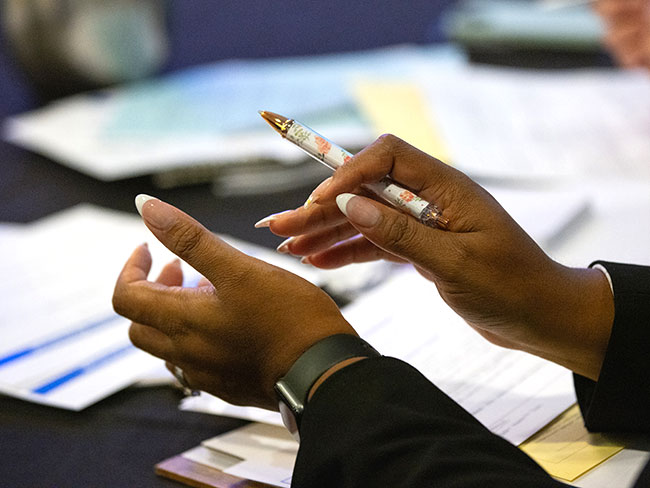 Close-up of a person's hands gesturing over papers on a table.