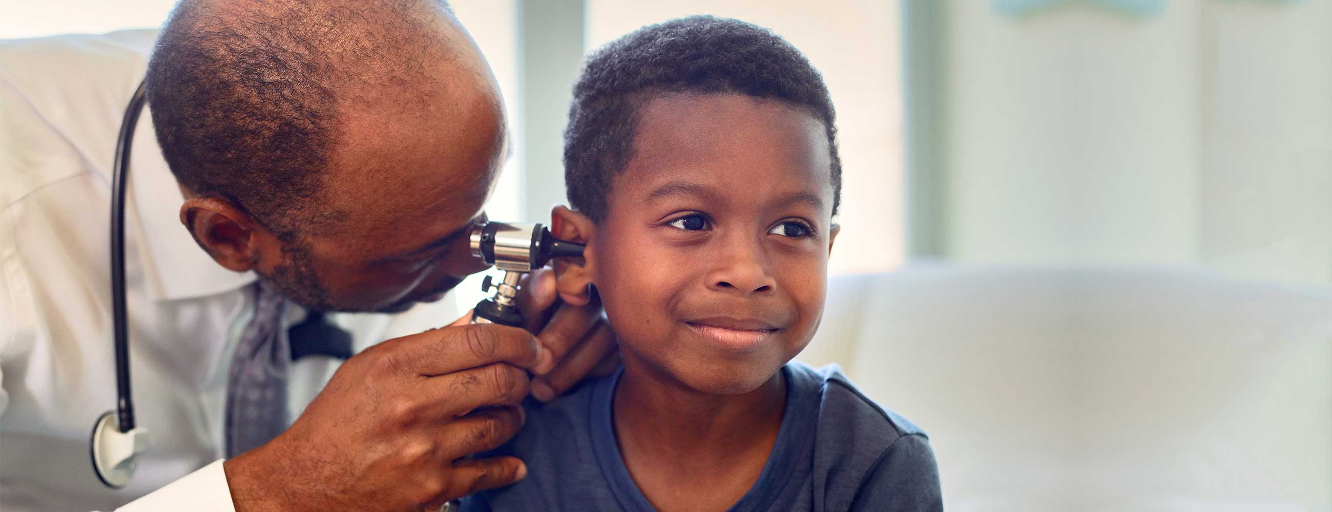 Doctor giving and ear exam to little boy