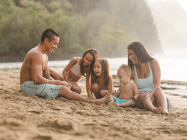 Family sitting on a beach in Hawaii