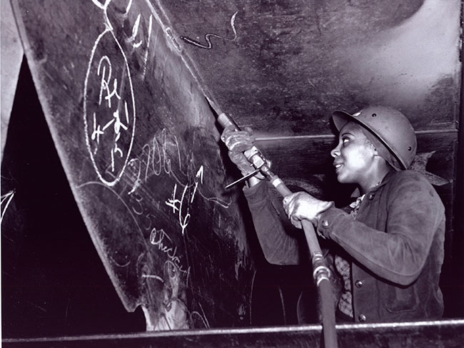 Eastine Cowner removing coatings and corrosion from Liberty ship SS George Washington Carver at the Kaiser Richmond shipyard in 1943.