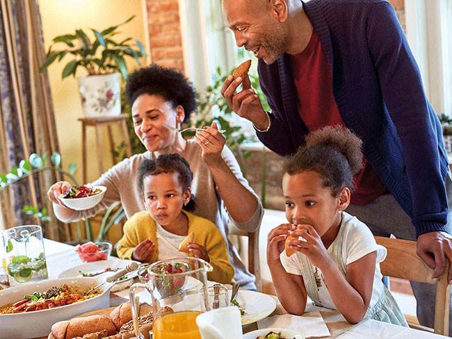 A happy family seated at a table filled with a holiday feast. 