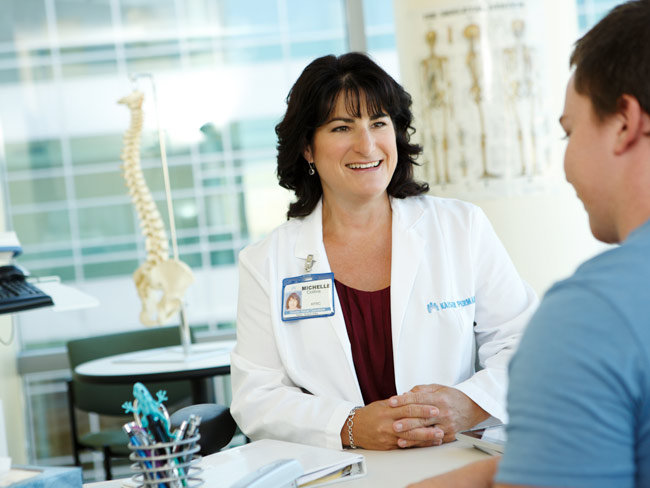 Kaiser Permanente doctor smiling and speaking with a patient