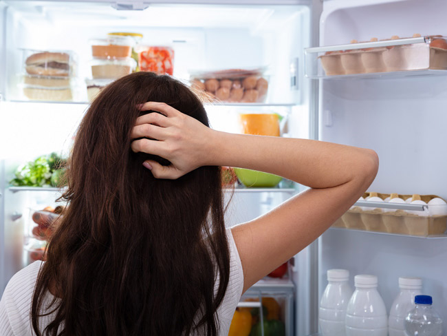 Woman standing in front of an open fridge