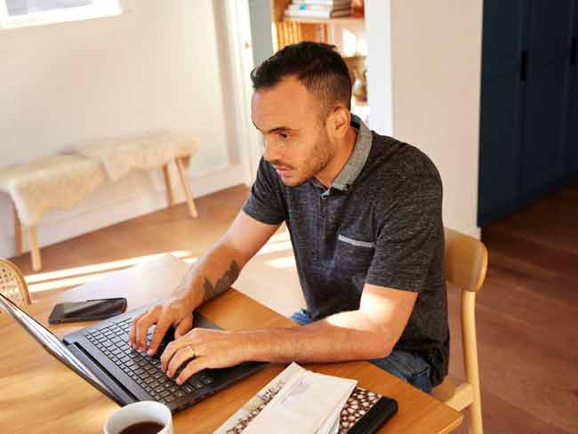 man working on laptop inside home office