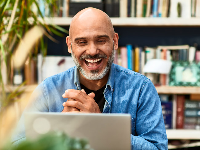 man smiling at laptop