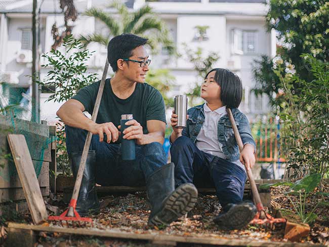 man seated with boy in garden
