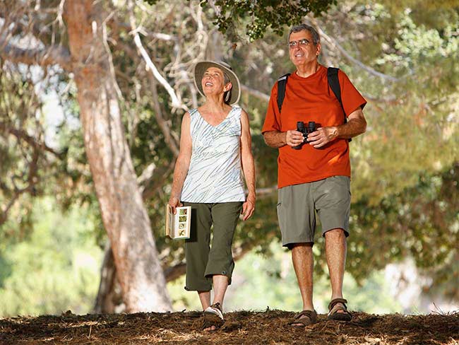 Senior couple hiking and birdwatching outdoors