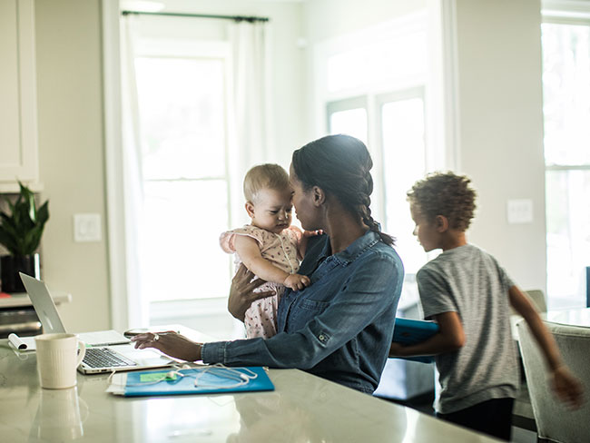 A mom, baby and child are in the kitchen