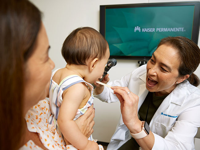 Doctor examining baby in mothers arms