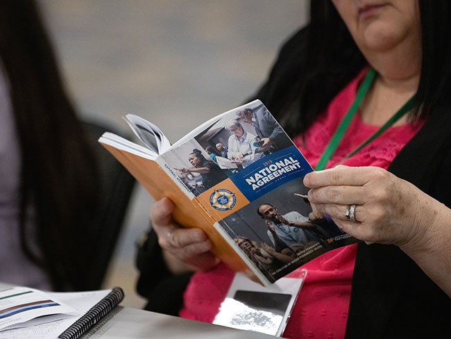 A woman thumbing through national agreement brochure