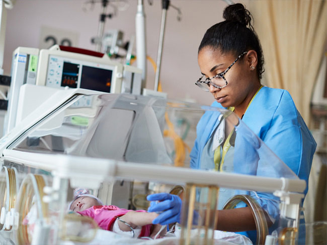 A nurse tends to a baby in the NICU