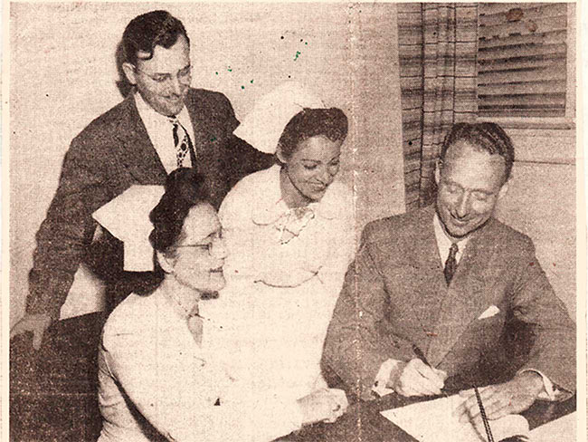 Newspaper clipping from 1946 showing two nurses with the Nurses Guild signing the first Permanente Foundation hospital nurses contract.