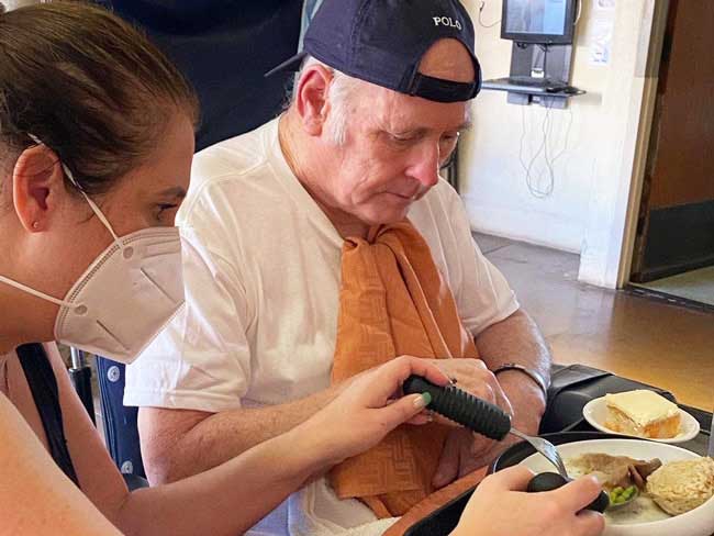 Melissa Fisher assisting her father, who had been diagnosed with dementia, to eat a meal.