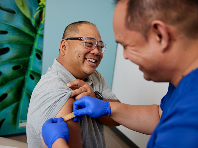 Registered nurse  applying bandage to a member's arm after a shot
