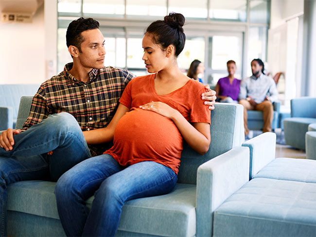 Pregnant woman and spouse in a waiting room